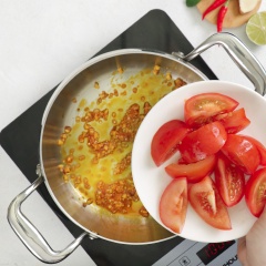 Bắc nồi lên bếp, cho 1 muỗng canh dầu màu điều, phi thơm 1 muỗng canh hành tím băm, 1 muỗng canh tỏi băm, cho tiếp cà chua múi cau, 1 muỗng canh sate tôm vào xào săn.