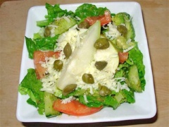 Cho hỗn salad vừa trộn ra đĩa. Lê cắt thành miếng nhỏ rồi cho lên trên đĩa salad. Sau đó rắc phô mai bào và một vài nụ bạch hoa lên trên rồi thưởng thức. Trước khi dùng trộn đều lên lần nữa nhé!