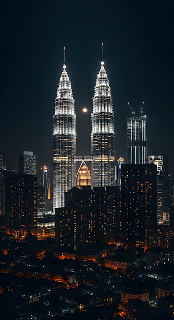 Dramatic Night View of Illuminated Petronas Twin Towers and Moon Over City Skyline - Free mobile Wallpaper