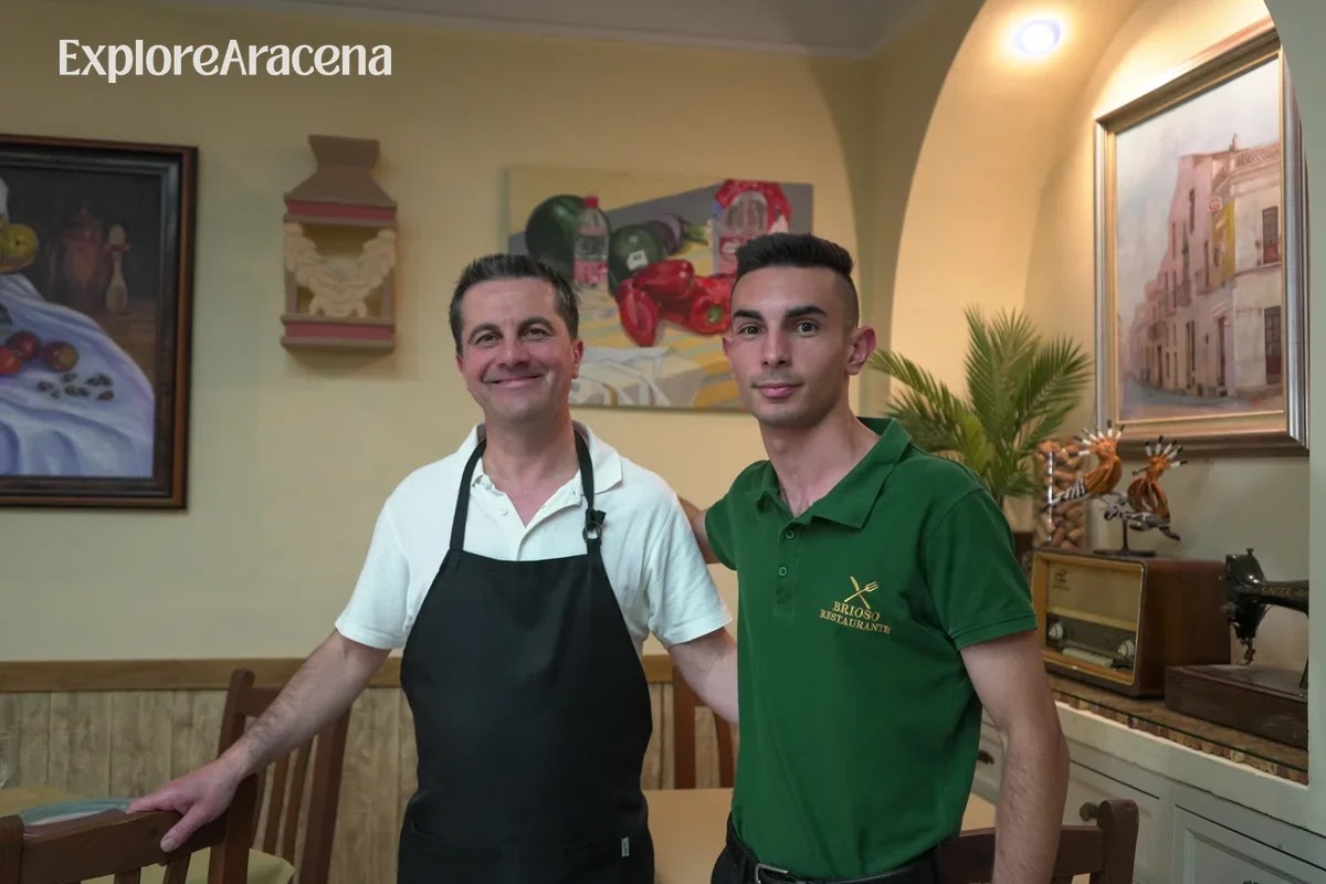 José Manuel Brioso and his son standing together inside their family-run restaurant in Aracena.