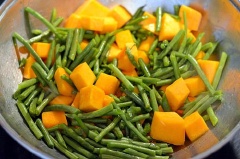 Đun nóng dầu olive trong một chảo to. Thêm hành tây vào xào cho đến đến khi hành có màu trong. Khoảng 2 phút. Thêm tỏi và hành tím băm xào trong 1 phút. Thêm bí, đậu que, muối, tiêu, nước tương rồi xào không đậy nắp trong 15 phút, thỉnh thoảng đảo đều.