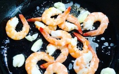 Phi thơm tỏi đập dập với 2 muỗng canh dầu ăn trong chảo, cho tôm vào, xào khoảng 2 phút.