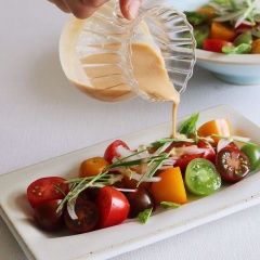 Cà chua bi rửa sạch, để ráo nước rồi cắt đôi. Hành tây, chanh cắt lát mỏng, hẹ cắt khúc. Nước sốt: cho 3 muỗng nước, 2.5 muỗng bơ đậu phộng, 1 muỗng đường, 1 muỗng giấm, 1/2 muỗng muối vào ly đong khuấy đều. Sau đó xếp cà chua, hành tây, hẹ ra dĩa rồi rưới nước sốt lên trên là có thể thưởng thức được rồi nha.