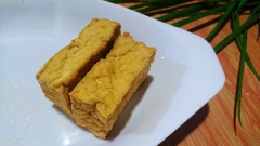 Đậu phụ mua về thấm khô, ép bớt nước và bóp nhuyễn. Dùng kéo cắt nhỏ phần vỏ vàng bên ngoài.