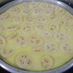 Bắc nồi nước sôi lên bếp. Quết ít dầu ăn vào khi khuôn nóng. Khuấy hỗn hợp chuối bột thêm một lần nữa rồi đổ vào khoảng 2/3 khuôn rồi xếp những lát chuối mỏng lên trên đây nắp lại hấp chín. Dùng đũa xăm vào bánh thấy không dính bột là bánh chuối hấp nước cốt dừa mềm béo đã chín. Lấy khuôn bánh ra để nguội.