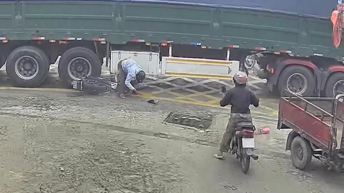Thót tim khoảnh khắc lái xe máy thoát chết hi hữu khi bị xe tải chèn qua - Báo Xây Dựng