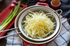 Gọt vỏ khoai tây, bào sợi nhỏ rồi ngâm khoai tây đã bào vào tô nước lạnh khoảng 5-10 phút rồi vớt ra, rửa sạch, giũ ráo nước.