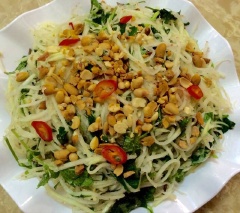 Cuối cùng, cho đậu phộng, rau kinh giới, húng quế, ngò rí vào, trộn đều. Bày món ăn ra đĩa và thưởng thức!