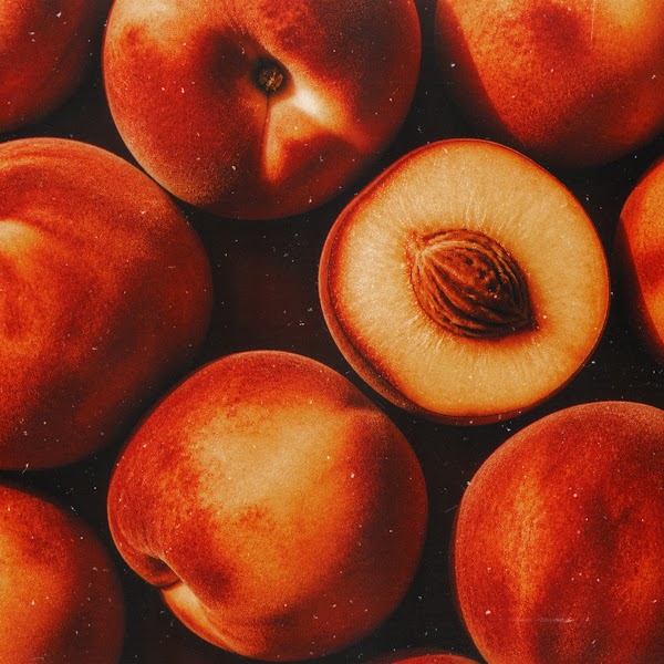Ripe peaches, one halved to show the stone