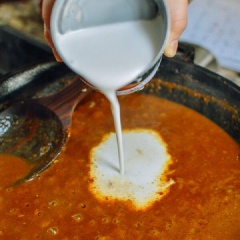 Cho tiếp vào chảo 1 muỗng canh dầu ăn và phần sốt cà ri đỏ cô đặc. Thêm nước dùng gà, bột cà ri, nước tương, nước cốt dừa, tiêu, đường vào. Đun sôi liu riu để hỗn hợp được sền sệt.