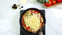 Bạn xào thơm nửa củ hành tây cùng 1 muỗng cà phê dầu Oliu. Sau đó, bạn cho cà chua, ớt chuông, bông cải vào xào chín. Cuối cùng cho trái Oliu và gà cắt miếng vừa ăn, xào cho nóng. Tiếp đến cho 30 ml rượu vang trắng, nấu cho cồn trong rượu bay hơi hết, sau đó thêm mì Ý vào và đảo đều. Nêm thêm muối theo khẩu vị cá nhân.