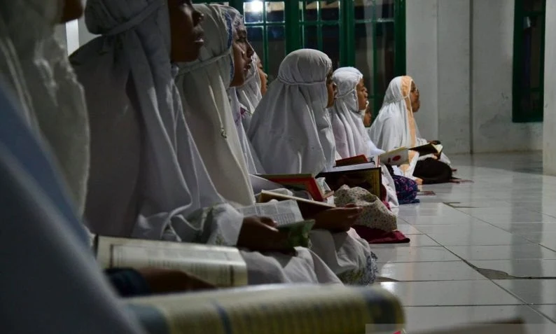 Guru ngaji sedang memberikan pendidikan keagamaan kepada anak-anak di Kabupaten Bogor.