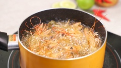 Chiên đầu tôm: Lăn đầu tôm qua lớp bột bắp. Bắc chảo lên bếp thêm dầu ăn đợi nóng, sau đó cho đầu tôm vào chiên giòn.