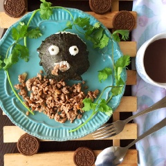 Cho cơm nắm rong biển ra đĩa, thêm thịt heo bằm vào và trang trí bánh oreo, ngò rí để món ăn trông hấp dẫn hơn.