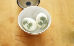 Trứng gà cho vào nồi nước, luộc chín. Sau đó, vớt trứng ra, bóc sạch vỏ. Ép rau ngò rí dính vào trứng, dùng băng cuộn quấn chặt lại.