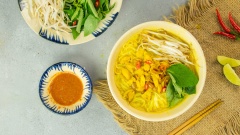 Tô bún nước kèn nóng hổi, nghi ngút khói thơm nức mũi với những miếng cá vàng ươm đang hòa quyện vào từng sợi bún thơm mềm, trắng tinh thấm đều trong nước dùng màu vàng sền sệt, điểm thêm chút màu xanh của dưa leo và rau thơm tạo nên sự hài hòa đẹp mắt và hấp dẫn.