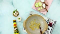 Bắt nồi đất cho 1 chút dầu ăn, khi lửa nóng cho thêm gừng và 10gr tỏi đã băm vào phi vàng thơm, rồi cho thịt heo quay vào đảo trong 1 phút.