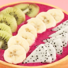 Cho hỗn hợp smoothie thanh long đỏ ra tô, dàn cho phẳng mặt. Nhanh tay xếp các loại trái cây topping như kiwi, chuối, thanh long thái lát vừa ăn. Xen kẻ đó là cát loại hạt như hạnh nhân lát, hạt chia cùng ngũ cốc và dừa sấy khô nếu thích. Vậy là bạn đã hoàn tất một tô smoothie chất lượng và rực rỡ sắc màu rồi.
