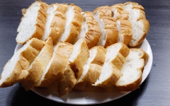 Làm nóng lò nướng trước 10 phút ở nhiệt độ 200 độ C. Bánh mì cắt thành từng miếng xéo dày khoảng 1-1.5cm, cho ra đĩa.