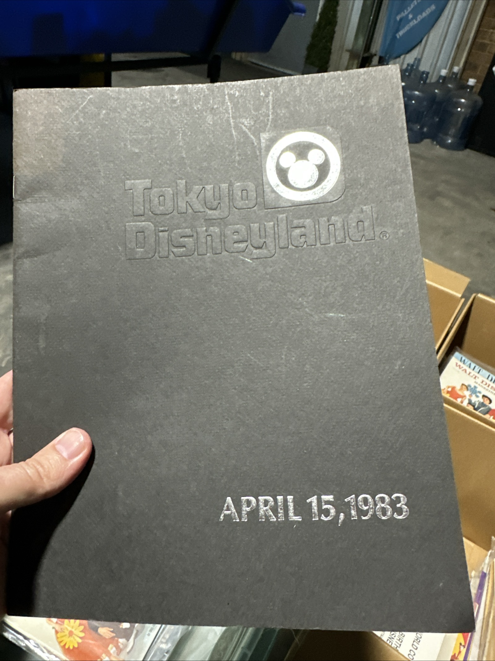 Tokyo Disneyland 1983 grand opening commemorative program folder, black textured cardstock with silver foil Mickey Mouse logo and debossed Tokyo Disneyland text