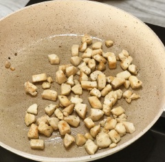 Tiếp theo bắc chảo lên bếp, thêm 1 muỗng canh dầu ăn đợi nóng cho thịt ức gà cắt hạt lựu vào chiên vàng đều các mặt. Sau đó đổ ra chén riêng.