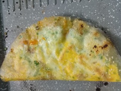 Khoảng 3 phút sau xịt tương ớt và sốt mayonnaise lên bánh => Gập đôi lại và nướng cho phần bánh tráng phía ngoài rìa chín vàng.