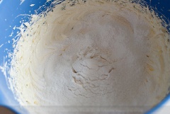 Đánh đều đến khi bơ trở nên bông nhẹ, thì cho 1 ống vani vào. Cho 1/2 phần hỗn hợp bột vào thông qua rây lọc.