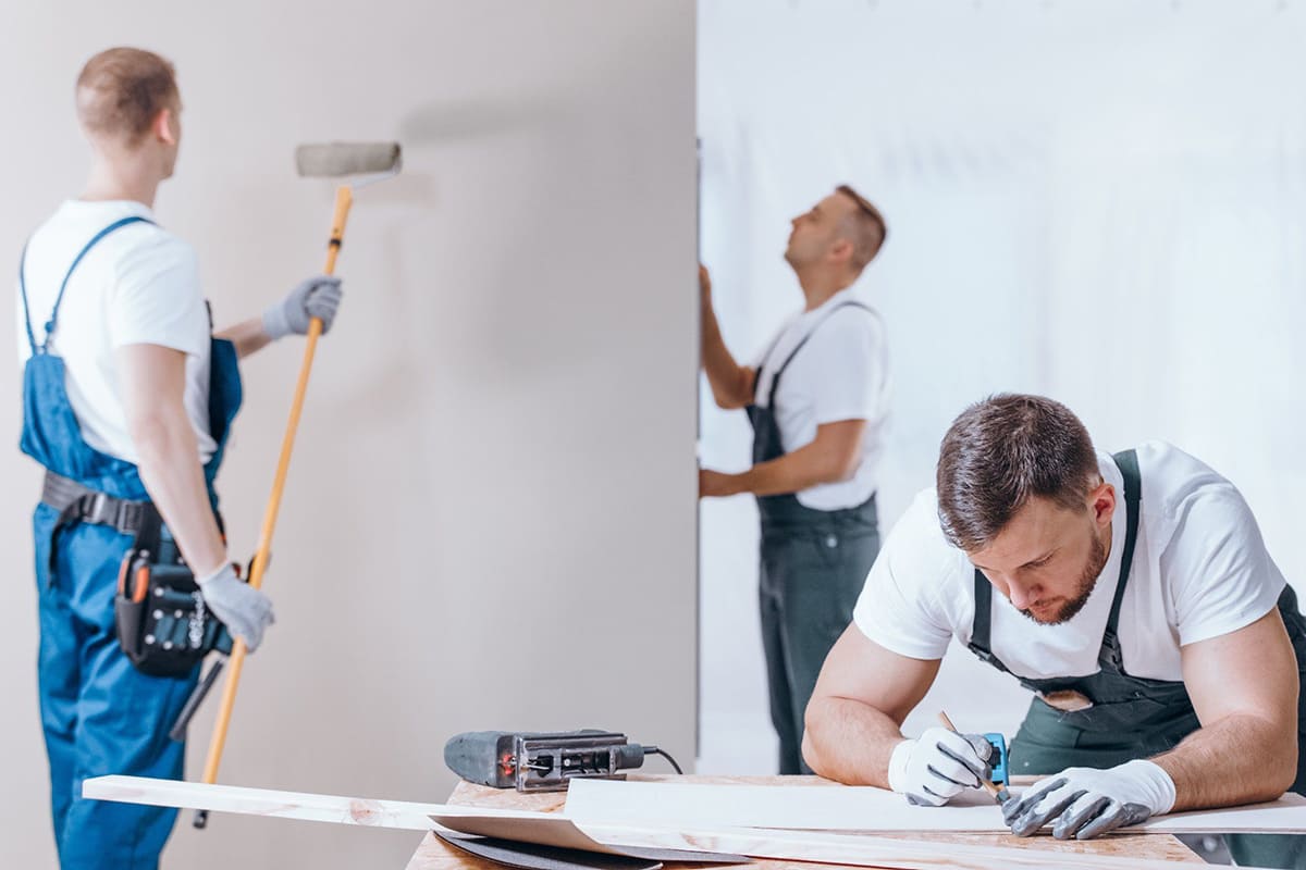 Equipo de pintores profesionales trabajando en vivienda de Tenerife, pintando paredes y preparando superficies