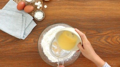 Cho vào tô lớn 270gr bột gạo, 30gr bột nếp, 30gr bột năng và 1 muỗng cà phê bột vani. Cho nước trứng gà lọc qua rây vào hỗn hợp bột, dùng phới dẹt trộn đều.
