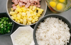 Chuẩn bị nguyên liệu: Thịt hộp thái hạt lựu. Thơm làm sạch, thái hạt lựu. Hành lá rửa sạch, băm nhuyễn. Trứng gà đánh tan trong một cái bát. Bắc chảo lên bếp, thả thịt hộp vào xào sơ cho chín vàng.