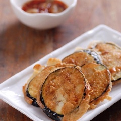 Cho dầu mè, nước tương, tỏi băm nhỏ và giấm vào chén khuấy đều làm nước chấm cà. Sau đó bày cà chiên ra đĩa ăn kèm cơm nhé!