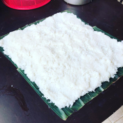 Xôi nếp vừa chín tới, xới đều, trải mỏng lên lá chuối. Nếu không có lá chuối trải mỏng ra mâm cũng được. Nhưng có lá chuối cơm rượu sẽ thơm mùi đặc trưng, bí quyết nhiêu đó thôi. Chờ xôi còn ấm ấm thì giã nhuyễn men rắc đều lên mặt. Sau đó gấp đôi miếng xôi lại rắc tiếp, rồi gấp 1 lần nữa rắc cho hết men. 1kg nếp sẽ cần 1 gói men cơm rượu mua ở chợ Việt Nam, men càng trắng cơm rượu thành phẩm sẽ trắng theo.
