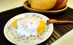 Xới xôi ra đĩa dàn mỏng, bày cả má xoài đã được cắt nhỏ lên trên, sau cùng chan nước cốt dừa và rắc thêm ít mè rang vàng.