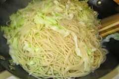 Đun nóng 2 muỗng canh dầu ăn, cho cá hộp anchovy vào đảo đều tay rồi cho tỏi băm vào. Cuối cùng là cho mì và bắp cải đã luộc vào, đảo đều tay.