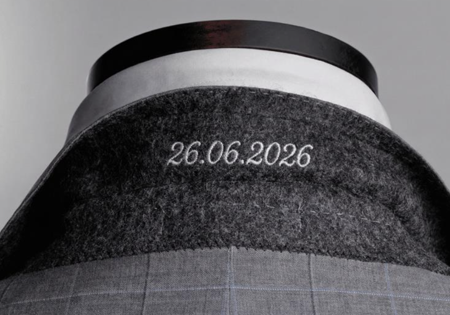Detail of a bespoke jacket undercollar with embroidered date showing hand-finished craftsmanship at Bespoke By CB