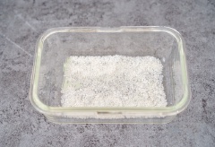 Trong một cái khay bạn rắc vụn dừa xuống dưới đáy. Đổ hỗn hợp thanh long vừa đun vào khay và dàn đều. Để khay bánh vào ngăn mát tủ lạnh qua đêm.