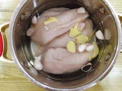 Lườn gà rửa sạch, cho vào nồi cùng với 1 củ gừng, 2 củ hành khô đập. Đổ nước vào nồi luộc gà. Khi gà sôi được khoảng 5 phút thì bạn tắt bếp, ngâm gà khoảng 10 phút.