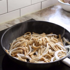 Đun nóng 2 muỗng canh dầu ăn, cho hành tây và chả cá vào đảo đều tay 1-2 phút. Nêm 1 muỗng canh nước tương, 2 muỗng canh rượu vang, 1 muỗng canh siro bắp, 1 muỗng cà phê tỏi băm, 1 muỗng cà phê đường, ít tiêu, xào tiếp 2 phút. Cho ớt xanh vào xào cho dậy mùi thơm. Cuối cùng thêm 1/2 muỗng canh dầu mè vào đảo đều, tắt bếp.