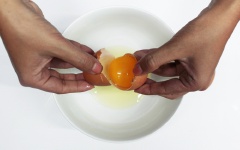 Trứng gà đập ra cho vào chén, dùng đũa đánh đều trứng để chuẩn bị nhúng vải.