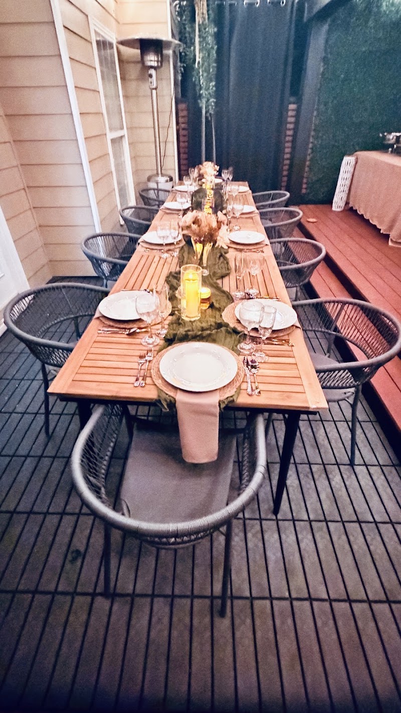 Long styled table with chairs at dusk with string lights