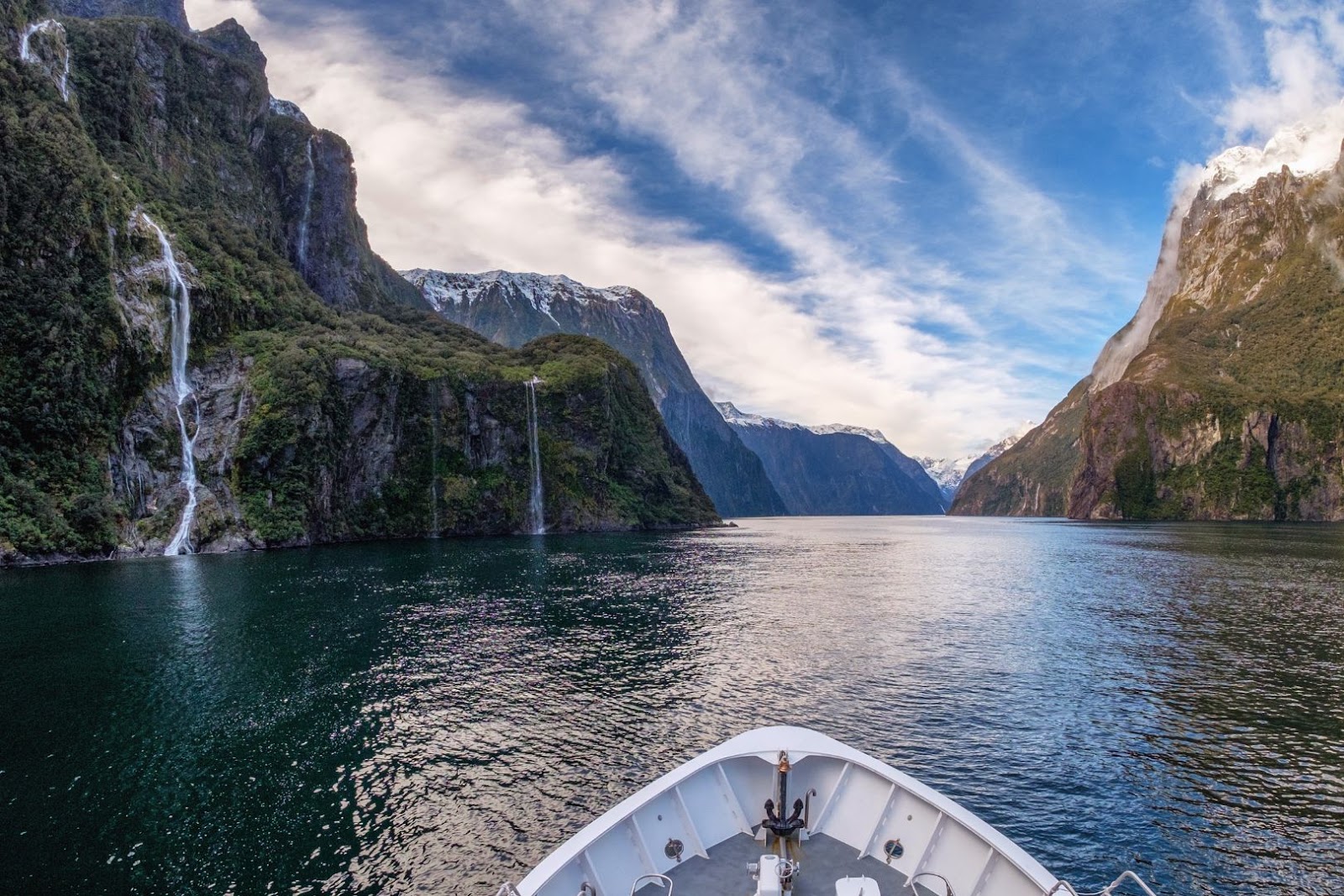 Milford Sound in New Zealand with steep mountains rising from the water beneath a dramatic sky.