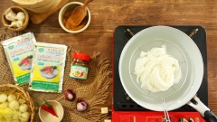 Trụng chín sợi phở cho vào tô; thêm rau thơm ngò ôm, ngò gai, đồ chua từ giá và cà rốt; thịt gà xé sợi, rắc hành phi và đậu phộng. Chan nước sốt sa tế dầu vào tô.