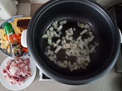 Bắc nồi lên bếp, cho dầu ăn vào phi thơm tỏi + hành tây vào xào đến khi hành tỏi hơi ngã vàng thì cho thịt ba chỉ vào xào chín, kế tiếp cho xúc xích vào xào cùng thịt. Thêm cà rốt + khoai tây vào xào cùng.