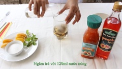 Ngâm trà túi lọc vào 120ml nước nóng khoảng 1 phút cho trà ra nước. Cho 2 muỗng cà phê đường, 1 muỗng sinh tố đào, 2 muỗng ăn siro đào vào khuấy đều.