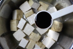 Đun nóng 2 muỗng canh dầu ăn, cho đậu hũ vào đảo nhẹ và đều tay. Sau đó thêm vào 1 chén nước lọc, 1 muỗng canh nước tương, 1/2 muỗng cà phê muối, 2 muỗng cà phê hạt nêm, 1/2 muỗng cà phê đường và 1/2 muỗng cà phê tiêu, đảo đều rồi đậy nấp nồi, đun lửa nhỏ.