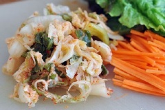 Cuối cùng, vắt bớt nước chua của kim chi cải thảo đi và để ra chén riêng, chuẩn bị cuốn nem ăn.
