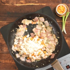 Làm cơm chiên: Bắc chảo lên bếp, cho vào 2 muỗng canh dầu ăn, phi thơm 10gr tỏi băm, cho vào 100gr thịt xông khói và 100gr tôm cắt hạt lựu, xào săn. Kế đến cho vào 50gr cà rốt và 50gr hành tây, đảo đều, sau đó cho vào 1 chén cơm trắng, xào đều cho cơm hòa quyện. Cho vào 30gr hành lá, nêm gia vị với 1 muỗng canh hạt nêm, 1/2 muỗng cà phê tiêu, đảo đều lần nữa rồi tắt bếp. Cho cơm chiên vào bát tạo hình.
