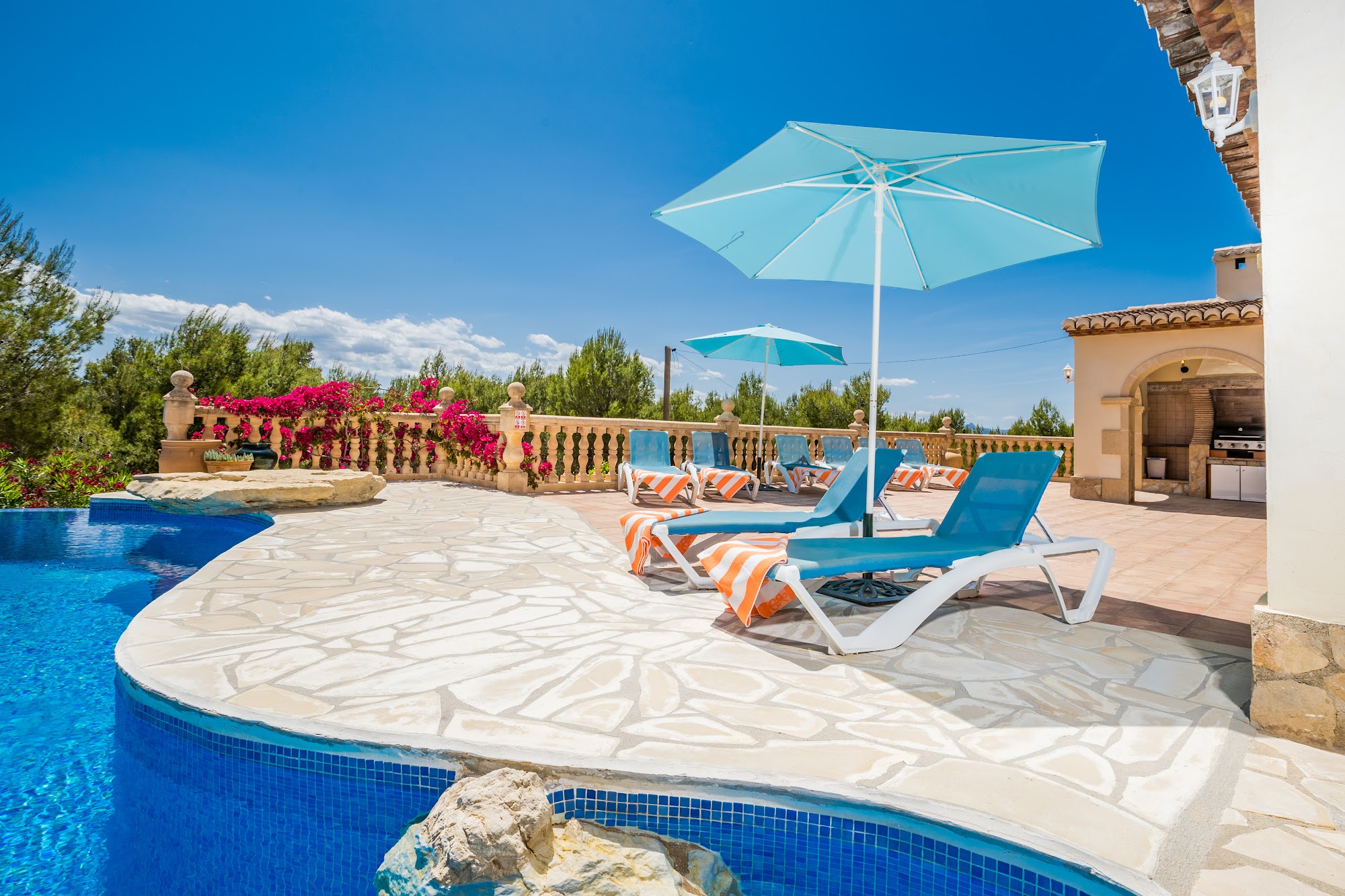 Pool with parasol and sun loungers