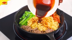 Bắc chảo lên bếp, cho vào 2 muỗng canh dầu ăn, cho thịt bò vào xào gần chín thì cho rau cải, kim chi và mì đã trụng vào trộn đều, rưới nước sốt vào đảo thêm 1 phút rồi tắt bếp.
