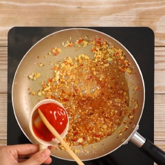 Phi thơm 2 muỗng canh tỏi băm, 1 muỗng canh ớt băm, rồi cho 2 muỗng canh đường vào thắng cho hơi ngã màu caramel, cho tiếp 2 muỗng canh nước mắm, 2 muỗng canh tương ớt, 2 muỗng canh nước cốt tắc, nấu sôi cho hỗn hợp keo lại, rồi trút phần mực chiên vào và đảo đều cho mực áo đều sốt.